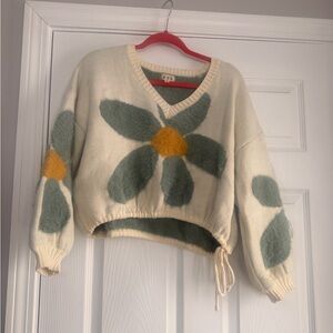 POL Cream V-Neck Sweater with Green Floral Accents and Yellow Center